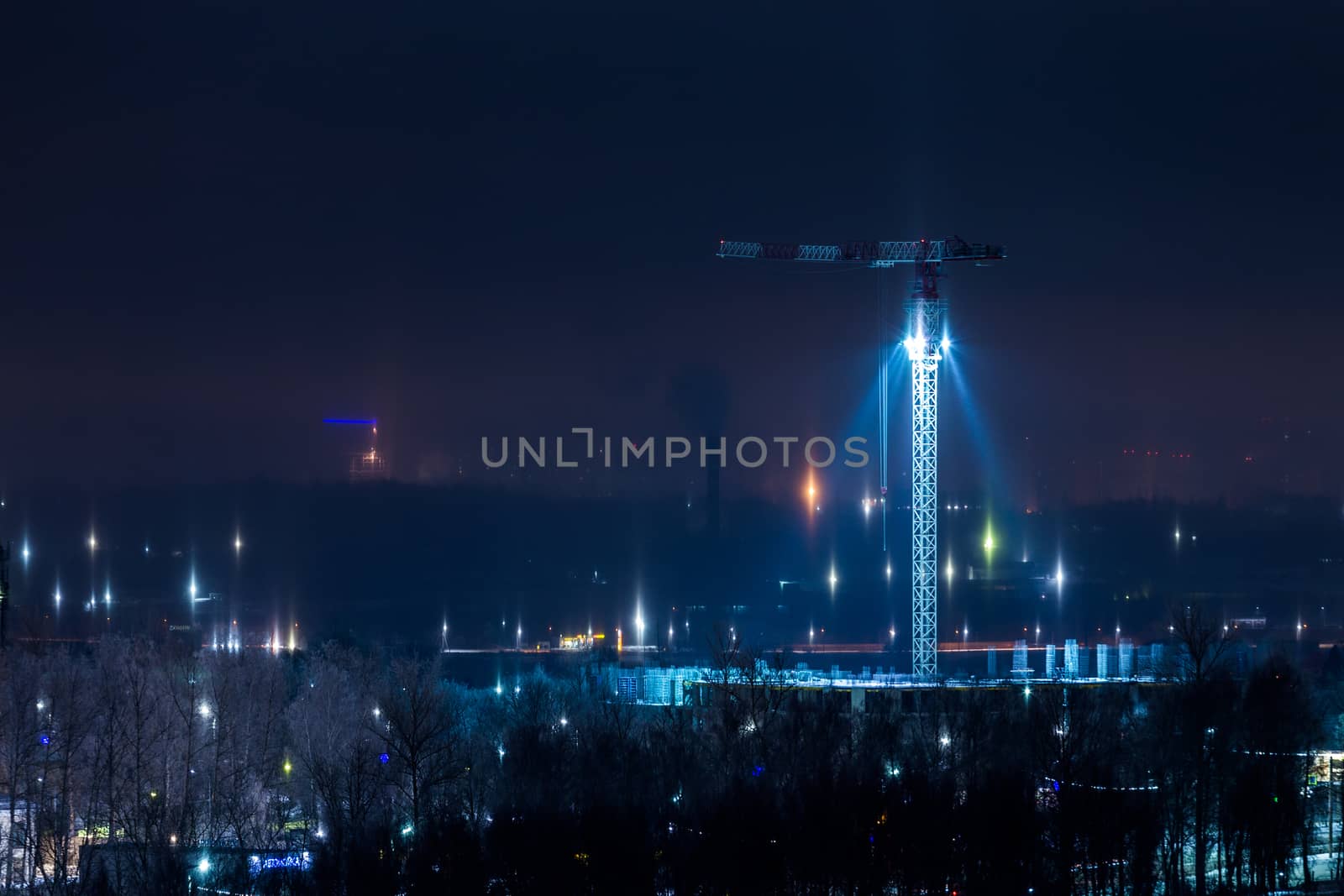 night winter cityscape with light pillars atmospheric phenomenon.