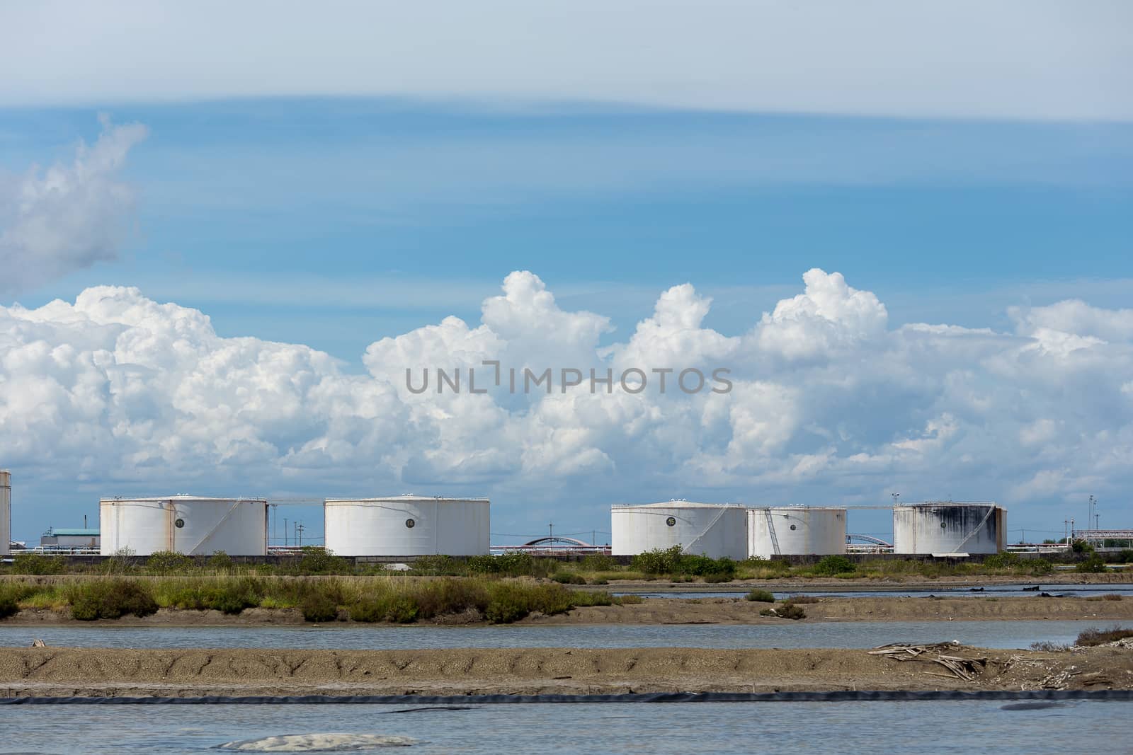 Oil tanks in a row under blue sky, Large white industrial tank f by kaiskynet