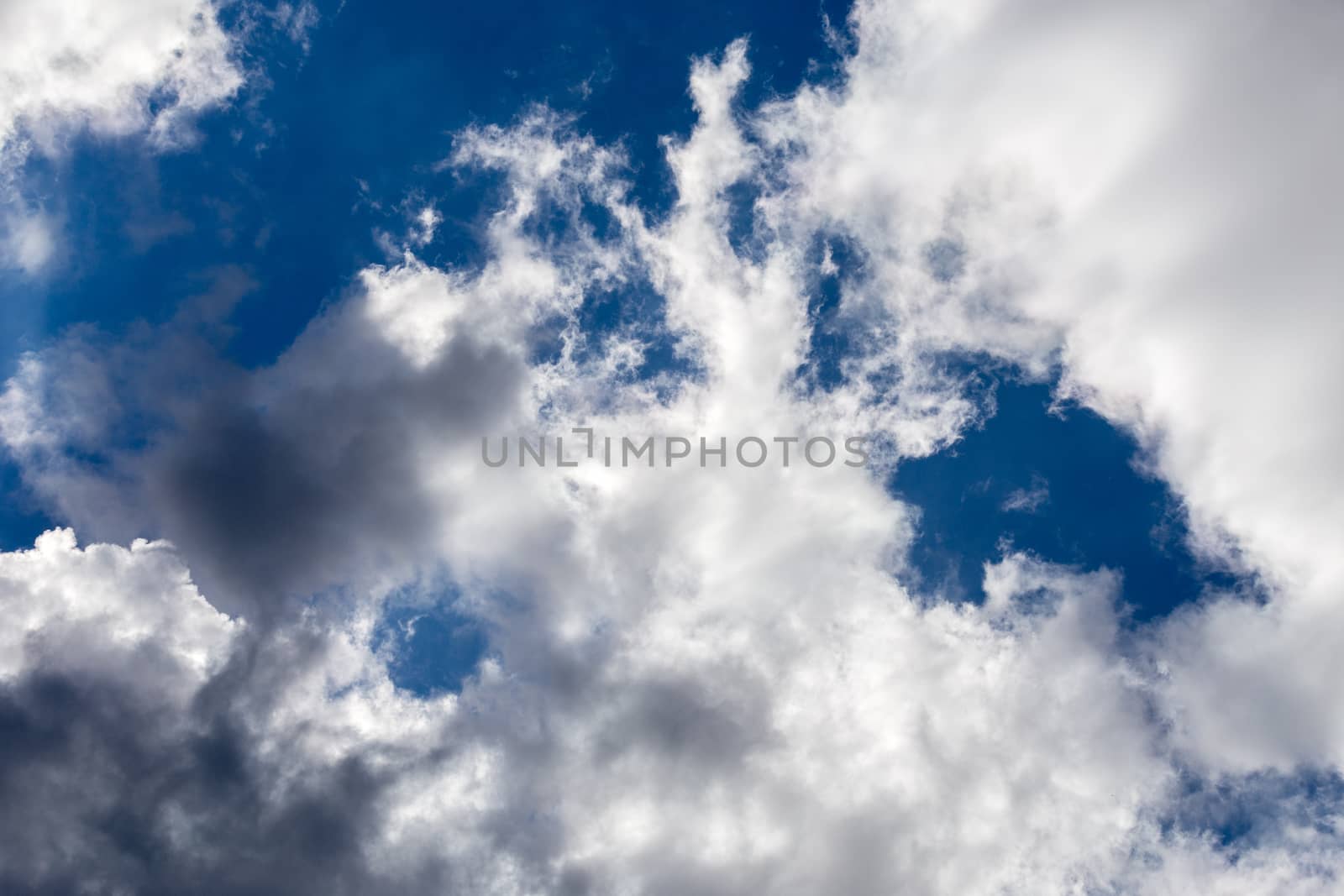 Regular spring clouds on blue sky at daylight in continental europe. Close shot wit telehoto lens and circular polarizing filter.