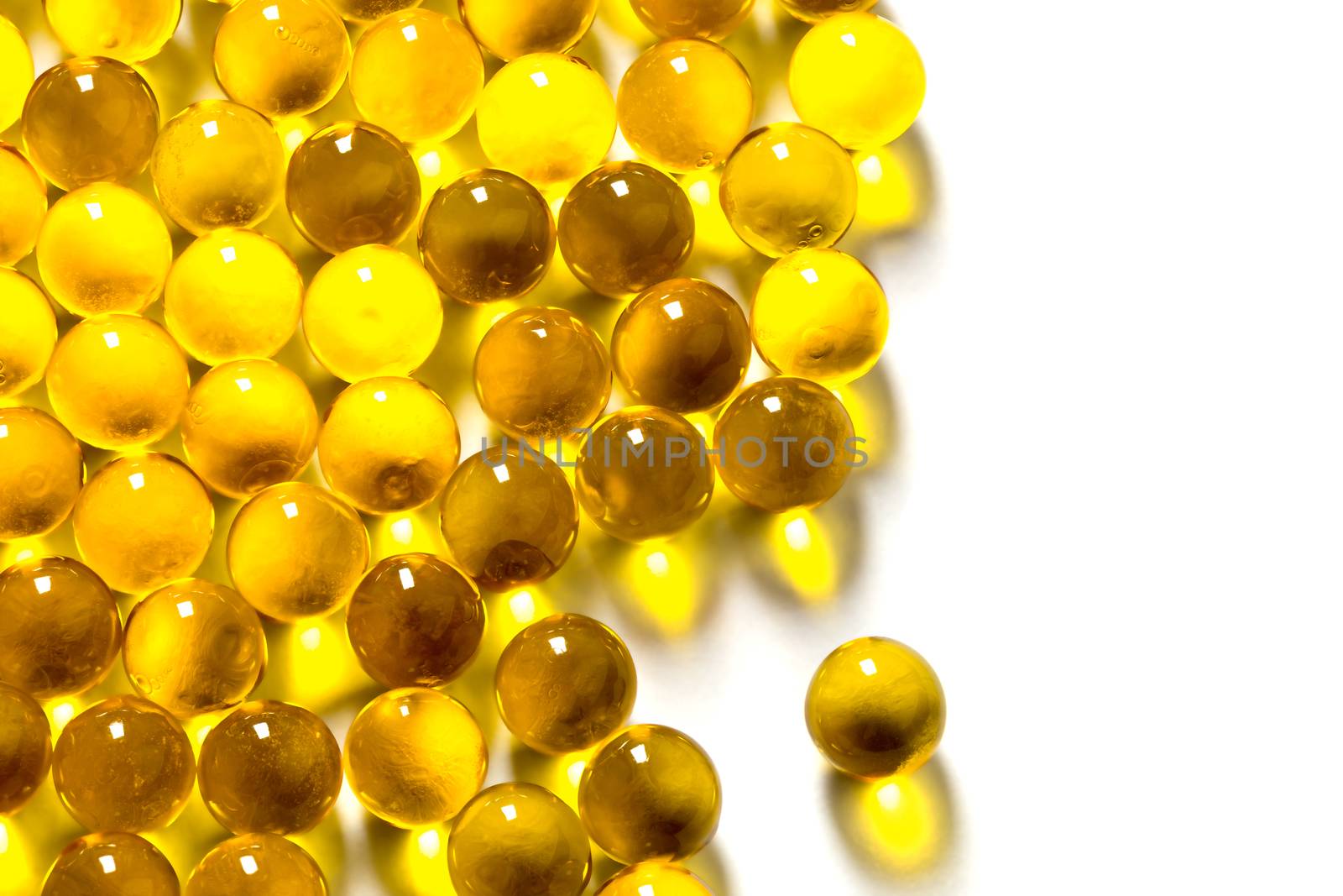 orange spherical ball capsules of fish oil selective focus isolated on white background.
