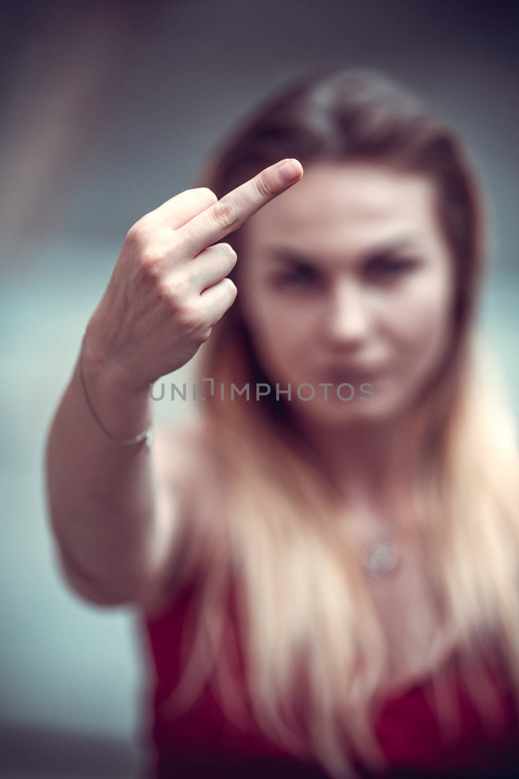 portrait of a beautiful young woman pointing her finger up as a sign of protest, fuck.