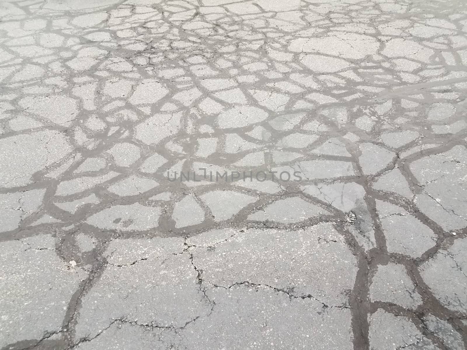 lines in cracked and damaged or worn black asphalt by stockphotofan1