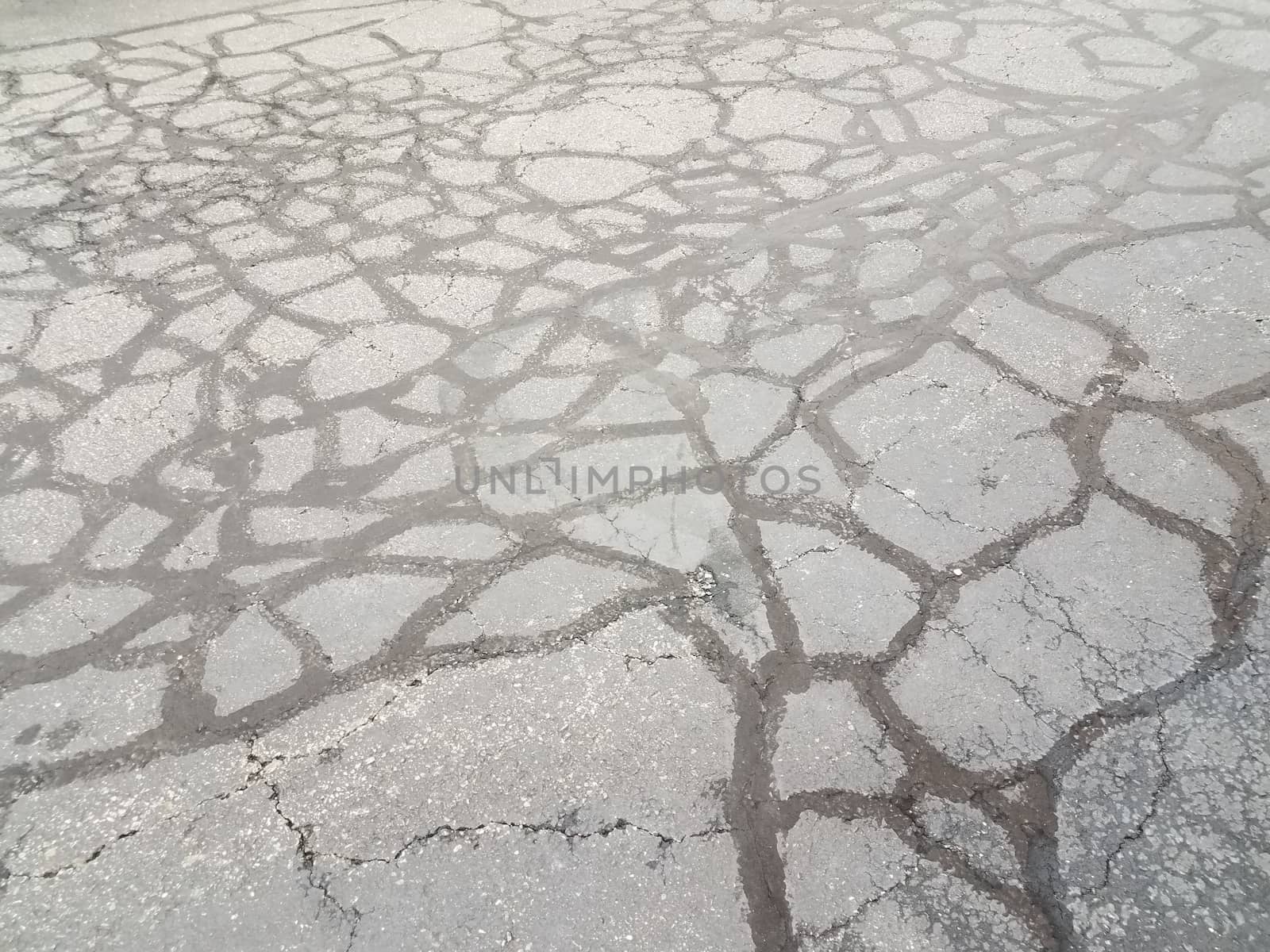 lines in cracked and damaged or worn or weathered black asphalt