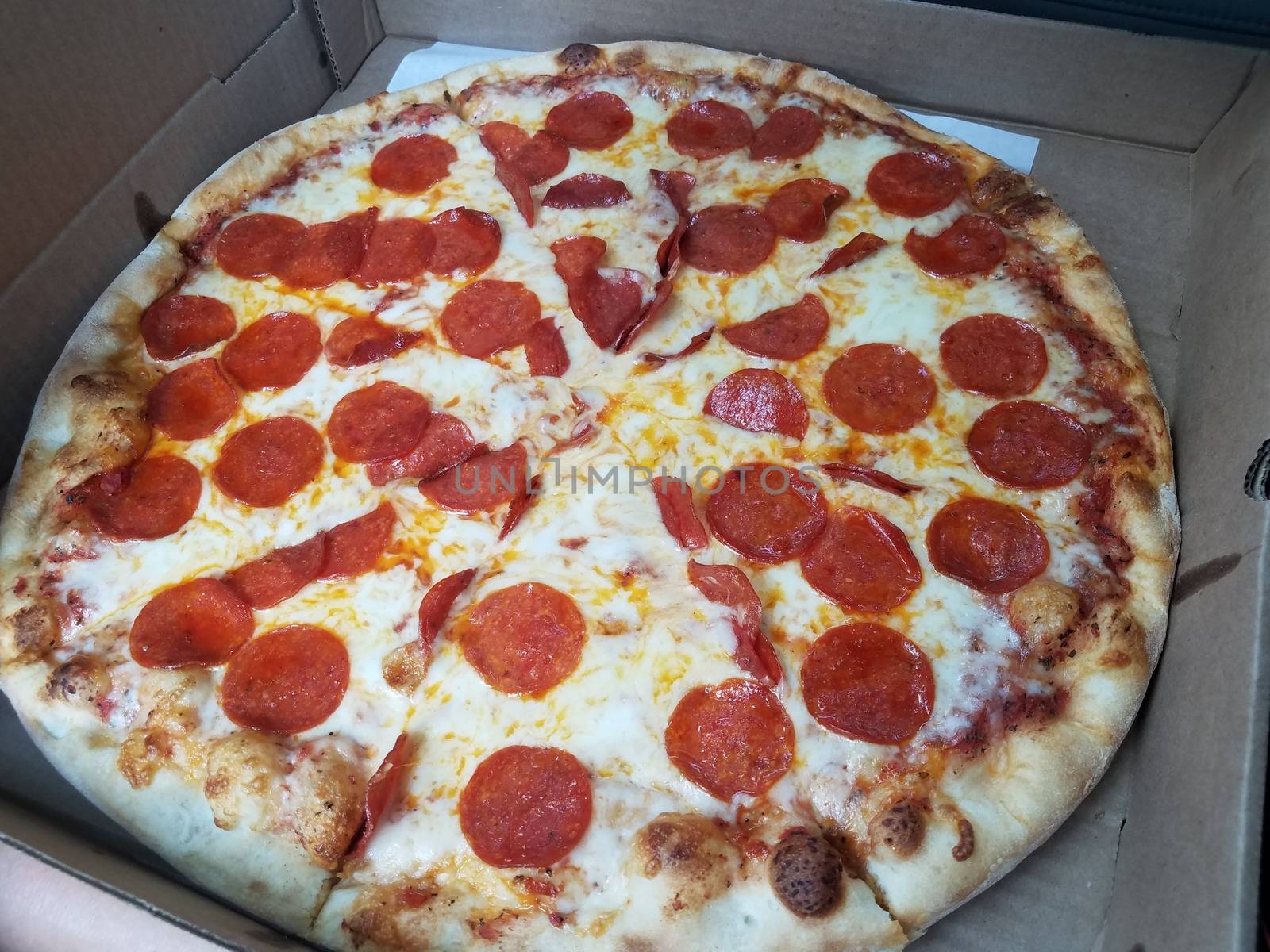 sliced pizza with pepperoni and cheese in cardboard box