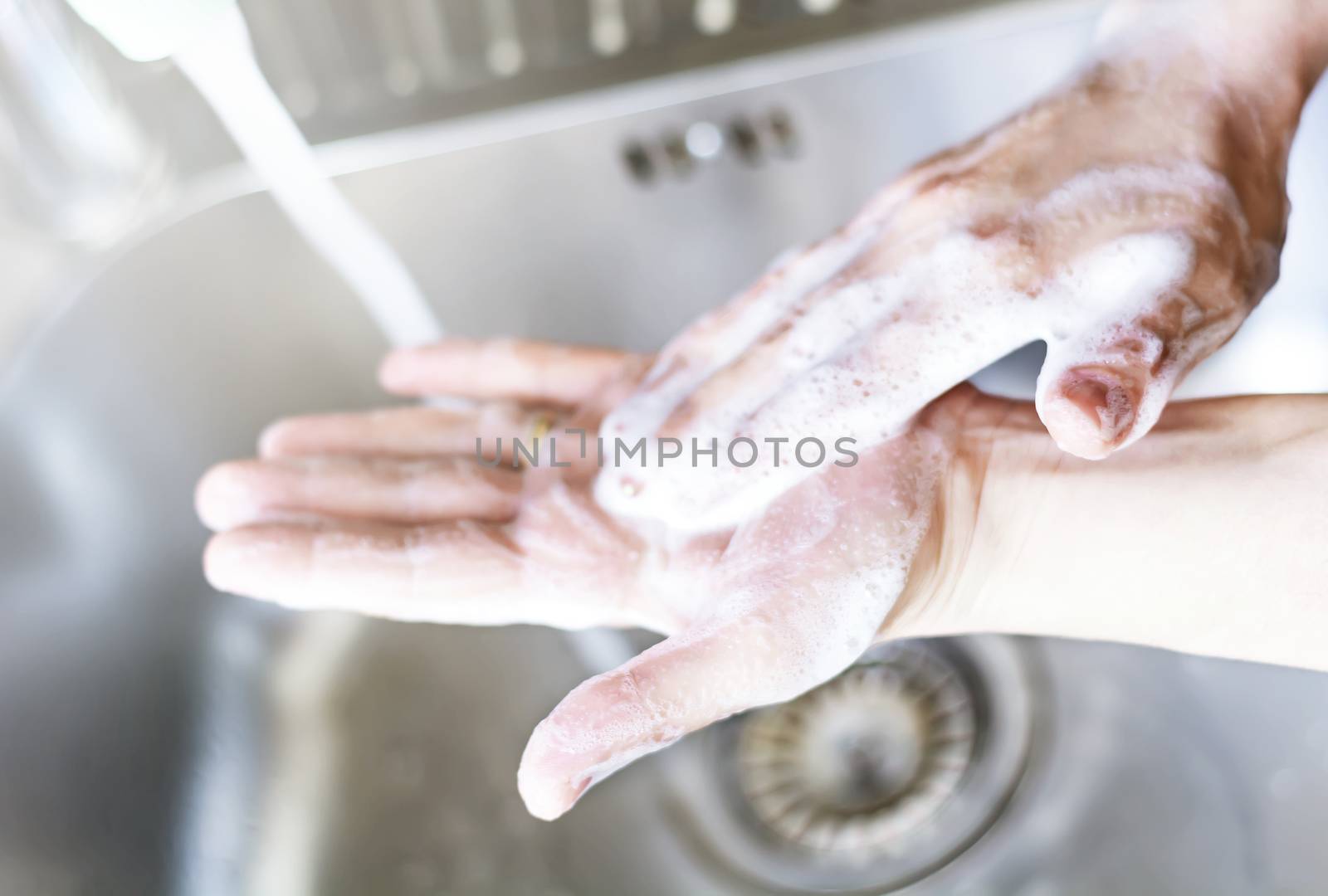 a young caucasian woman washing her hands with soap. by rarrarorro