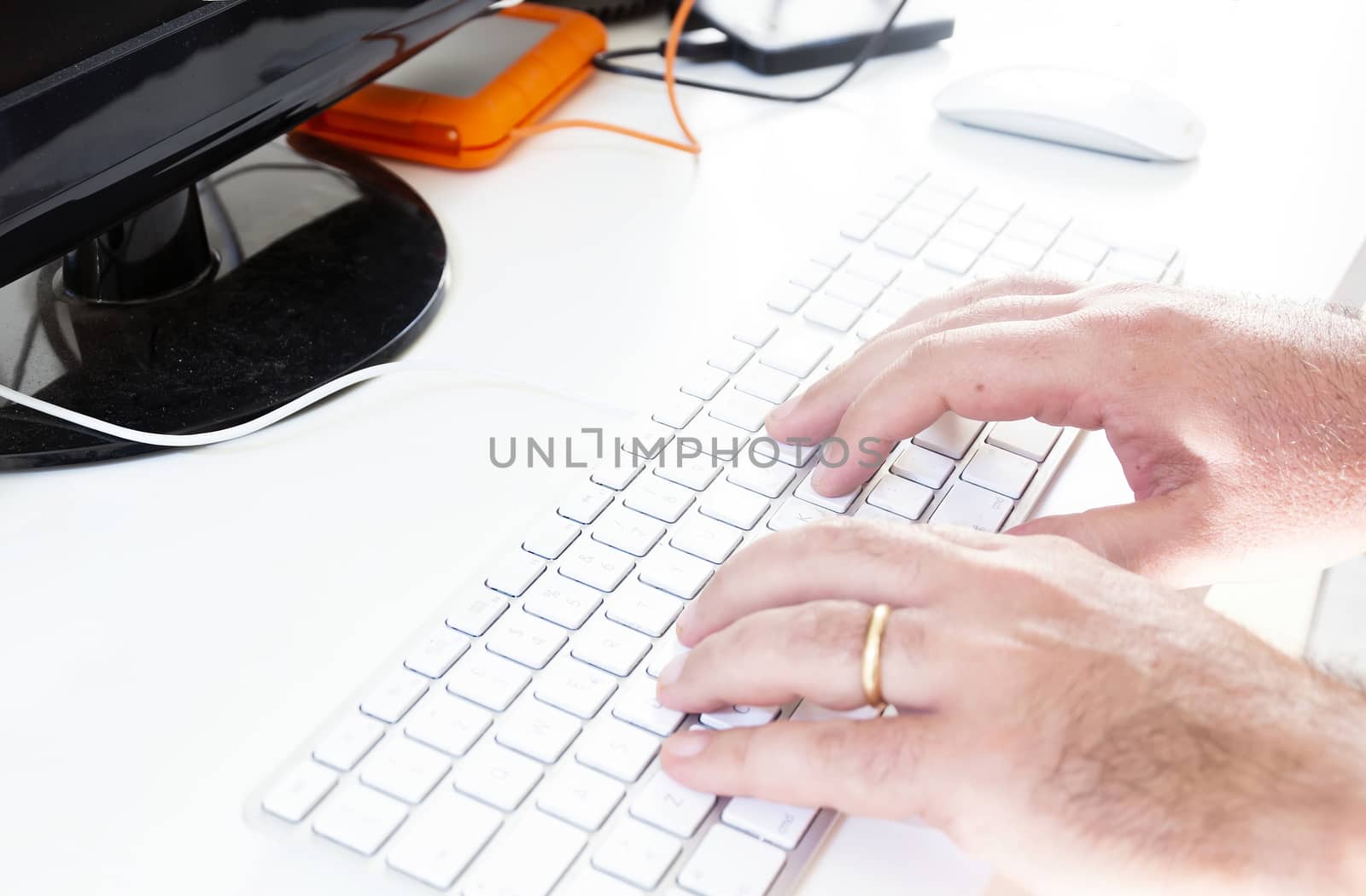 male hands typing on gray computer keyboard with white keys. Work and office. Technology and creativity. White background.