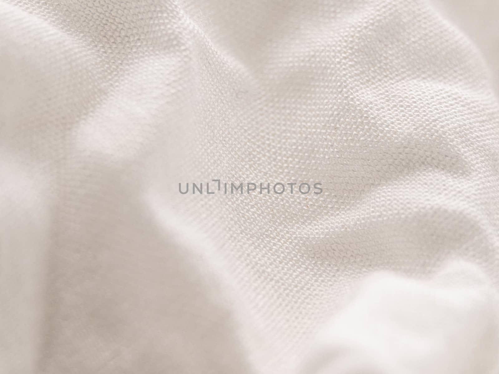 Texture of white fabric shows a soft, comfortable feel. Abstract background.