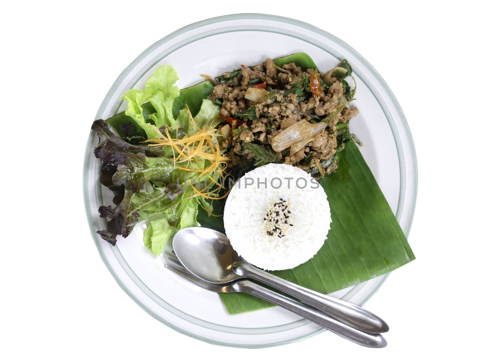 Thai food rice topped with stir fried pork and basil served with vegetables isolated on white background. top view.