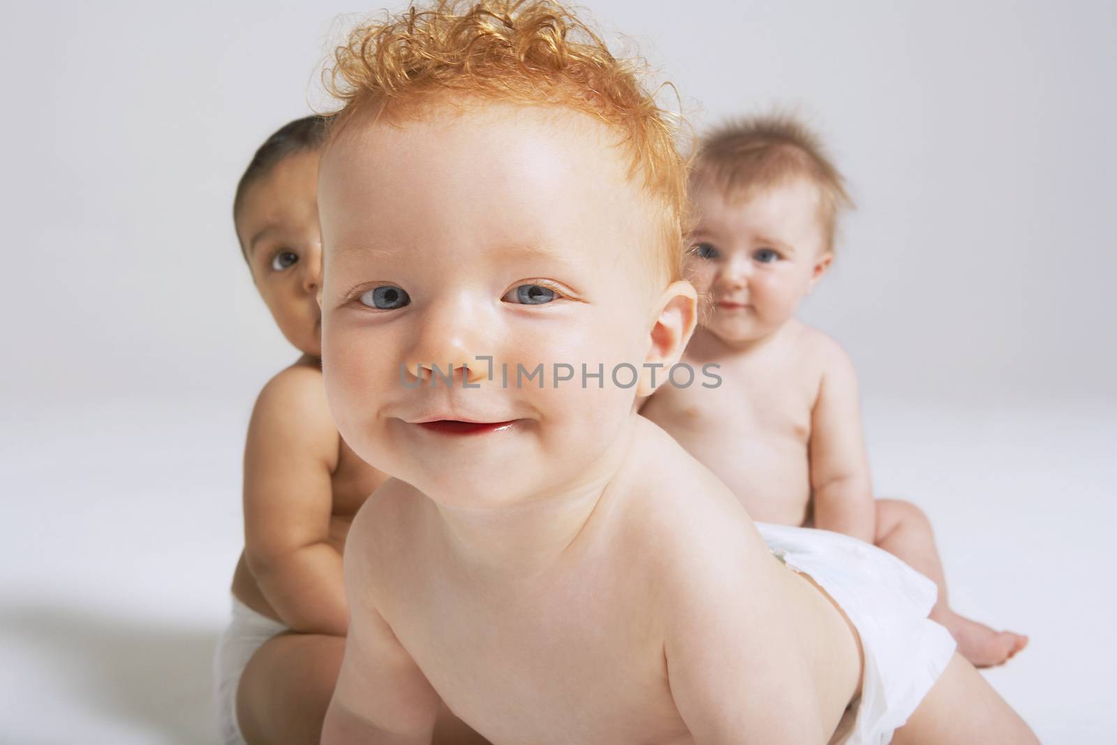 Portrait of three cute babies in studio by moodboard