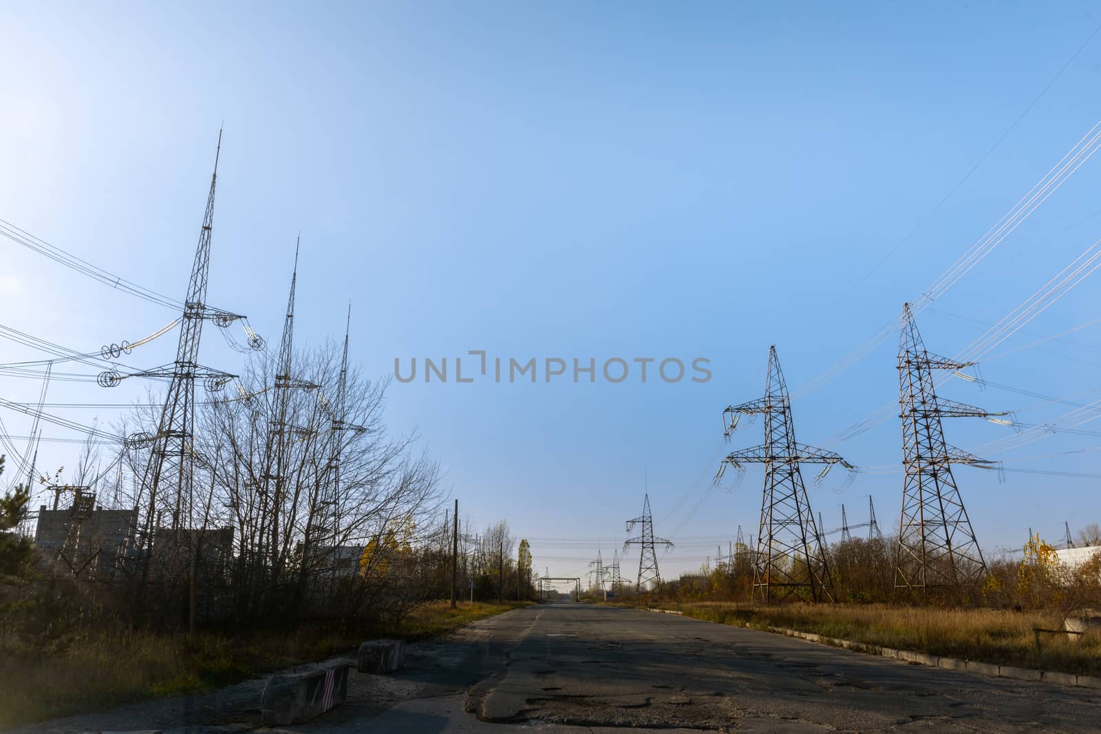 Large pylons at power distributing station under blue sky