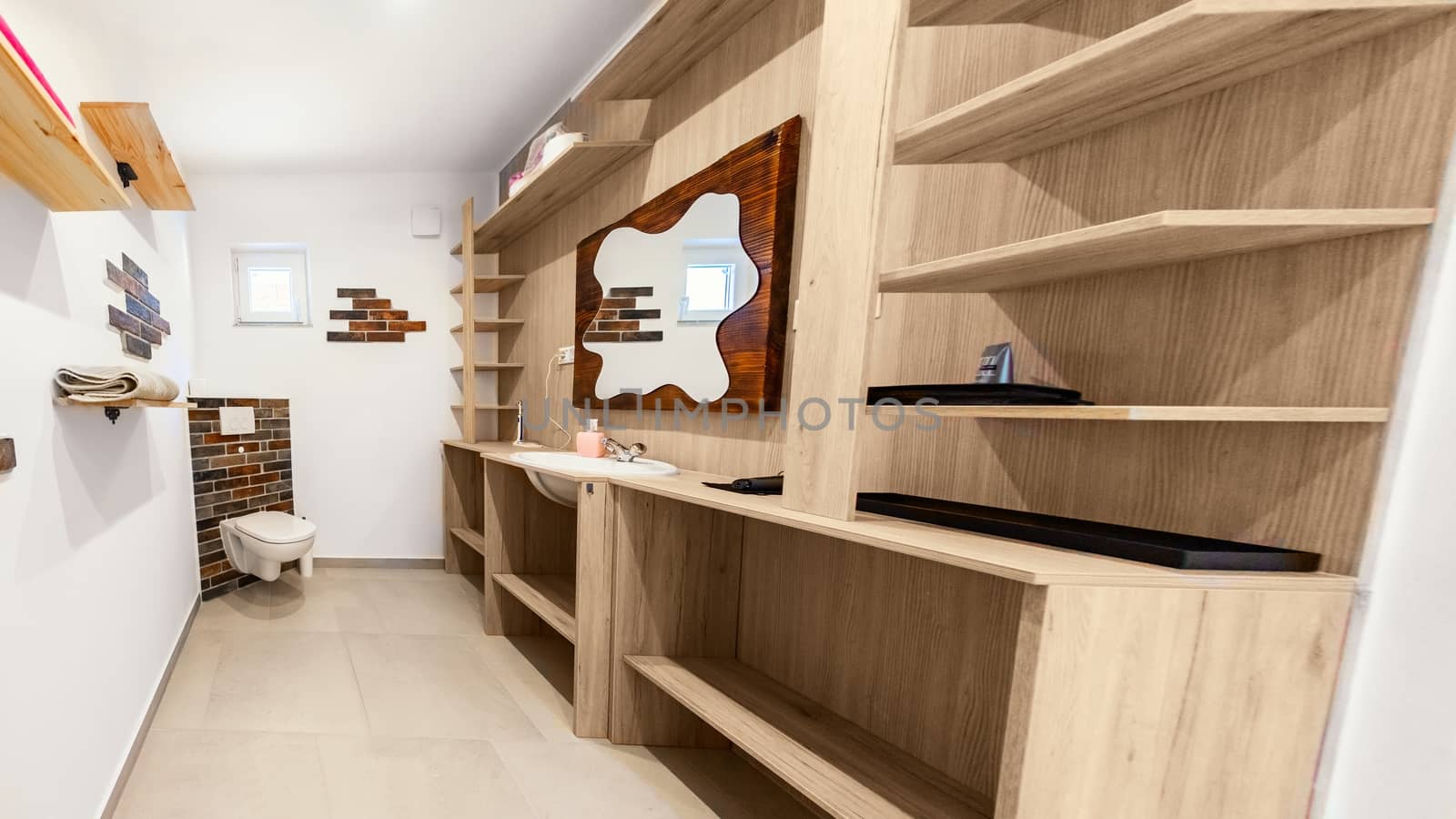 Bathroom in luxury apartment angle shot with wooden furniture