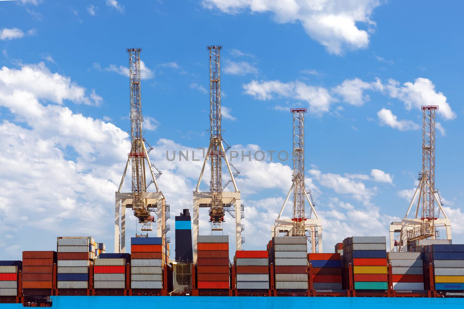 Large industrial port with many cranes and cargo containers