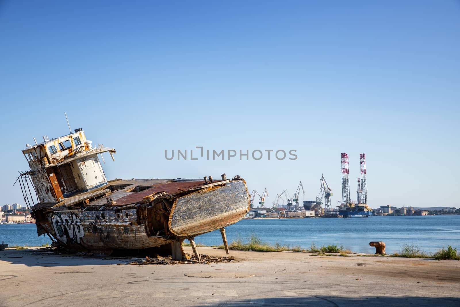 Old shipwreck at the harbor under blue sky