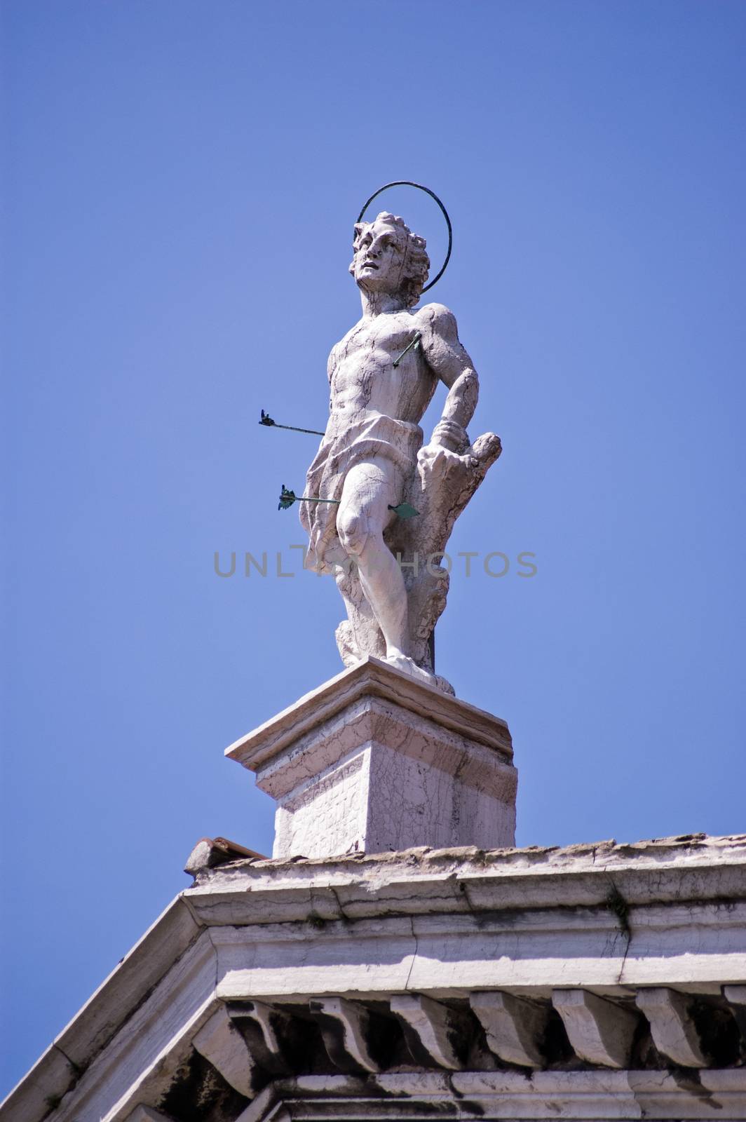 Statue of the Christian martyr Saint Sebastian. Shot with arrows, on top of the Chiesa di San Sebastiano, Venice, Italy.