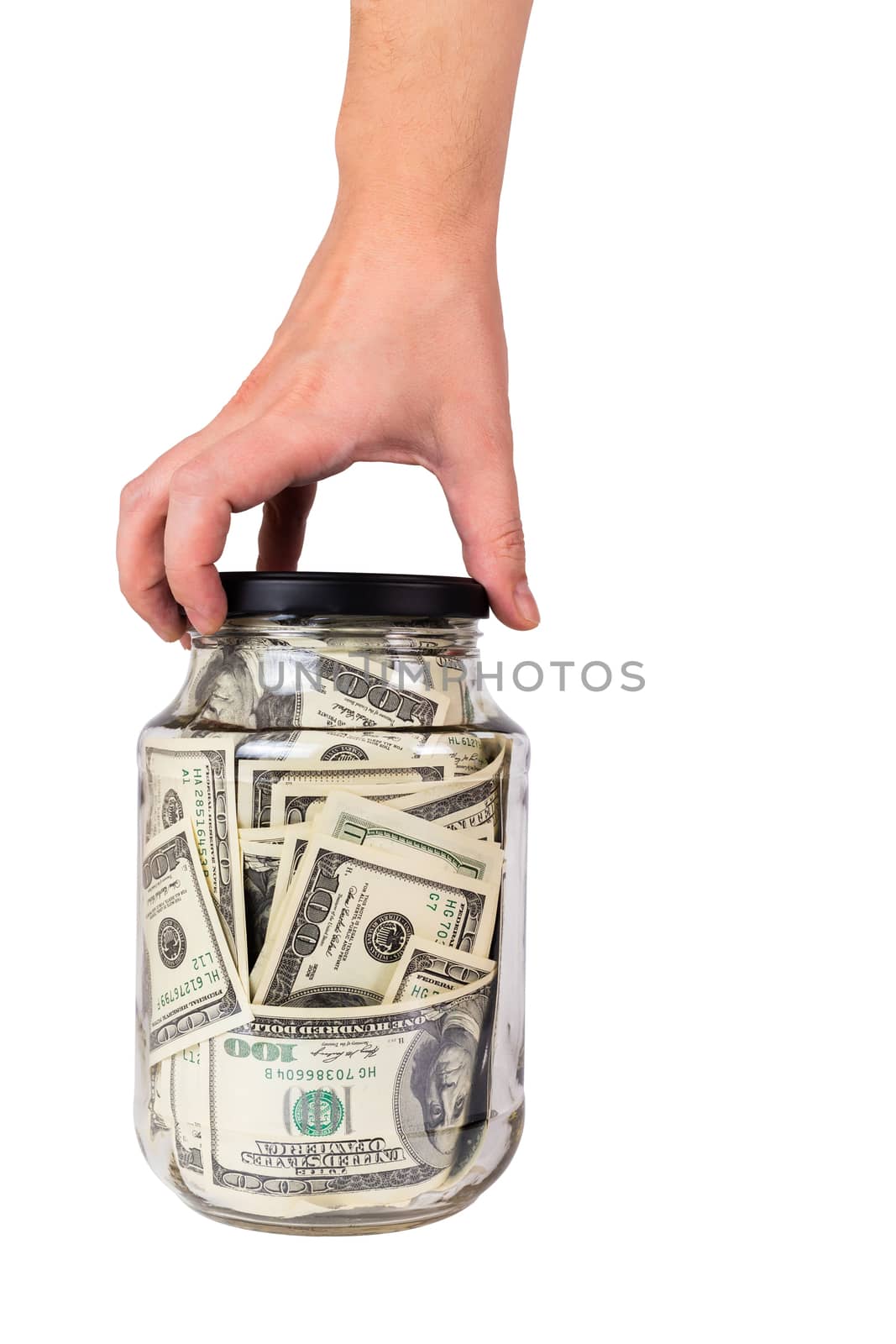 hand holding glass jar with black cap full of us dollar banknotes isolated on white background