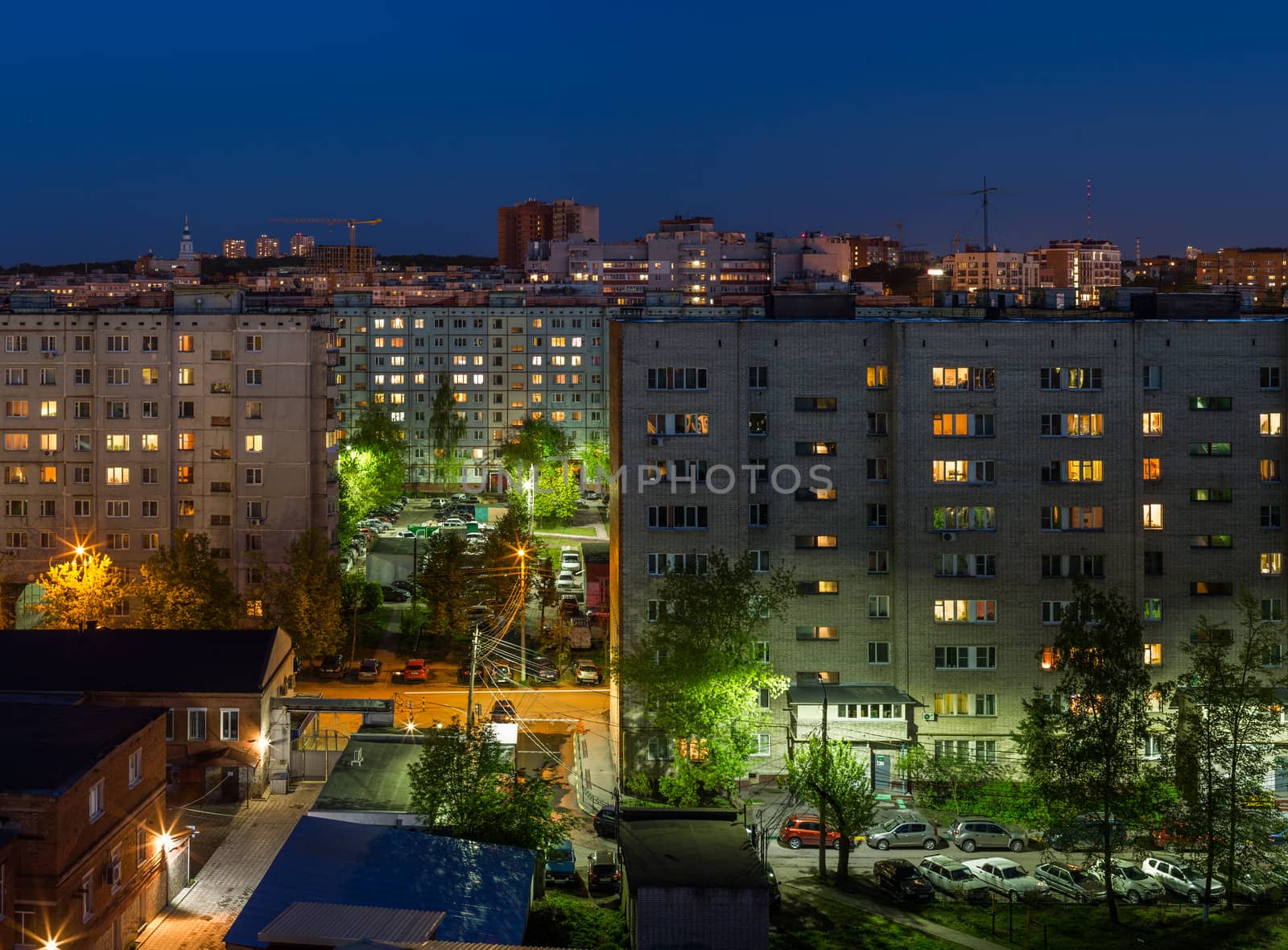 Windows, roofs and facade of an mass apartment buildings in Russia at at summer night
