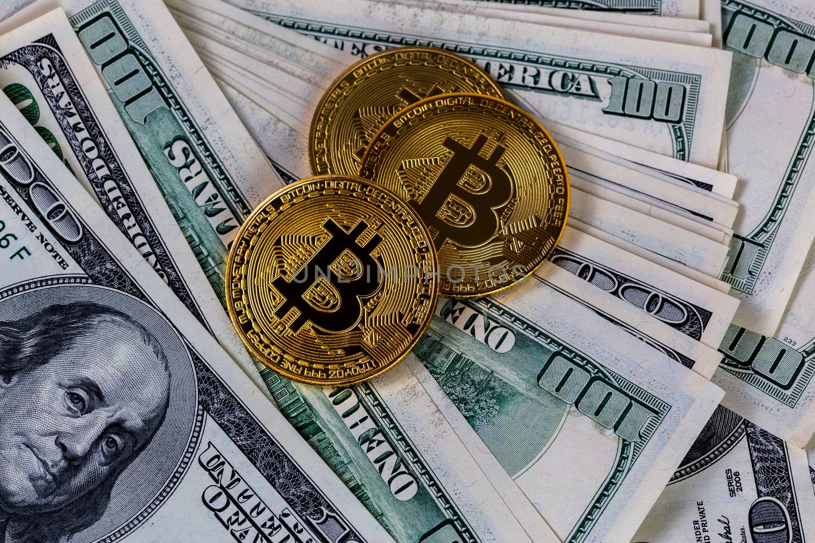 three bitcoin shiners on paper us dollar banknotes background.
