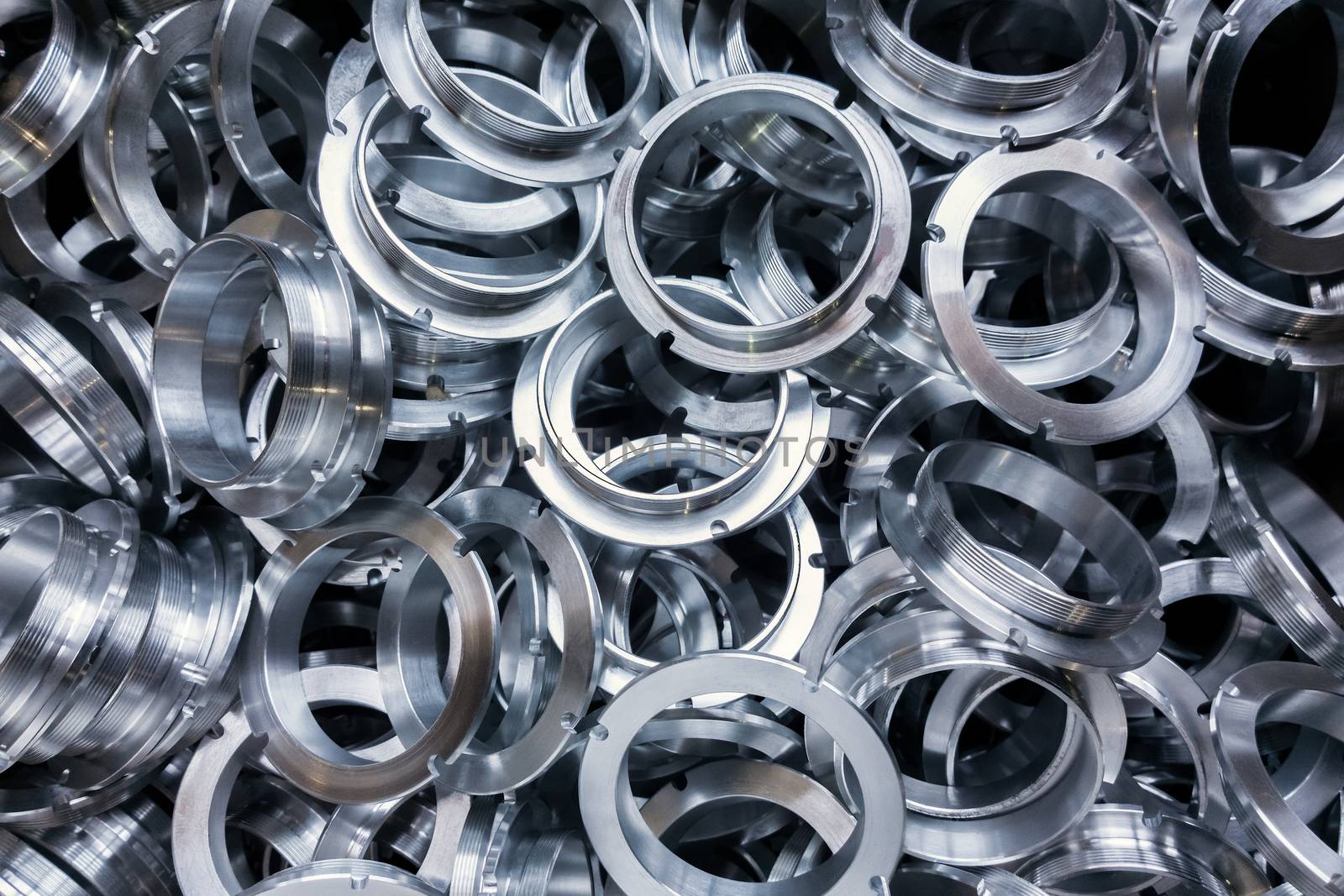a batch of machined shiny metal parts with selective focus.