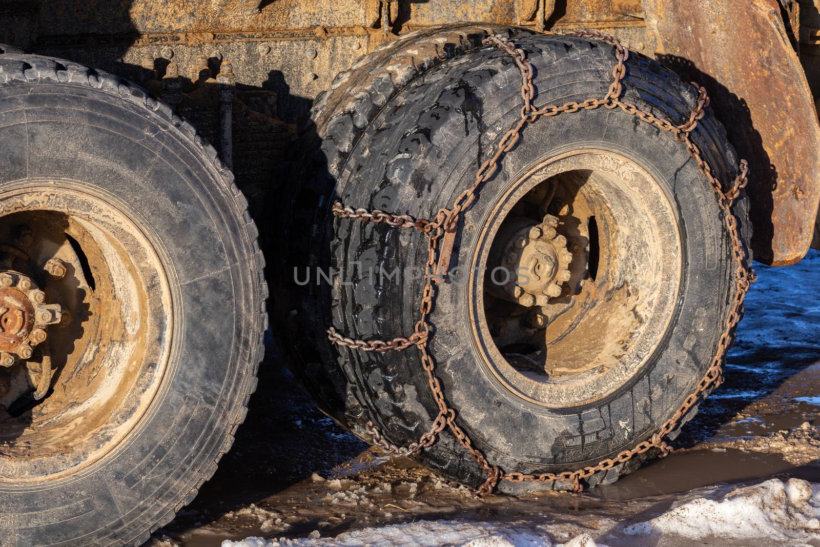 anti-skid chain on freight truck wheels at winter daylight closeup.