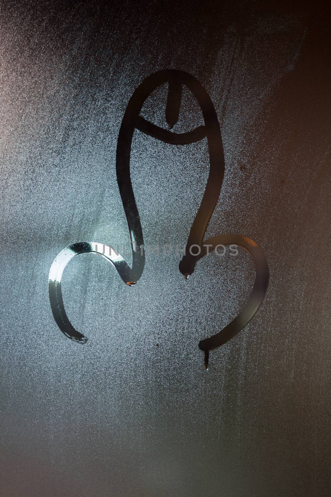 dick symbol drawed by finger on wet glass window at night - close-up with selective focus
