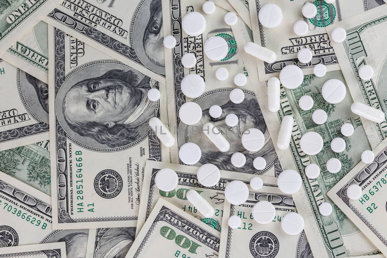 pills flat background, tablets spreaded on a us dollar banknotes - top-down view.