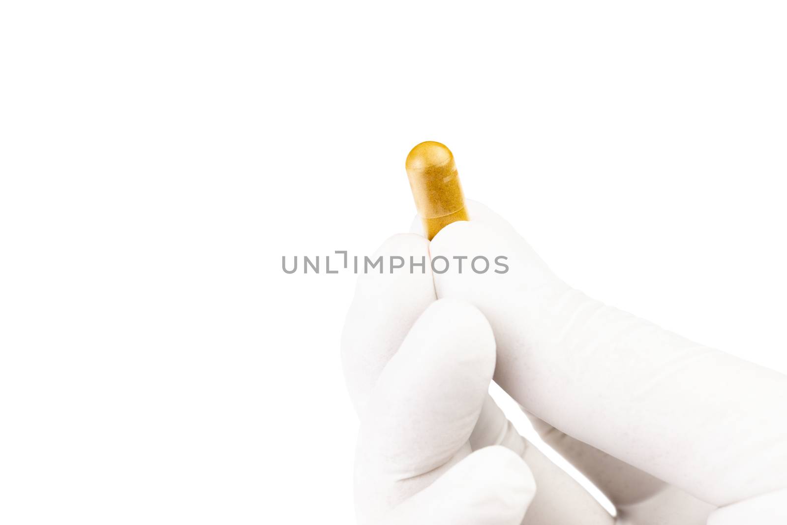 hand in medical glove holding organic med capsule isolated on white background closeup.