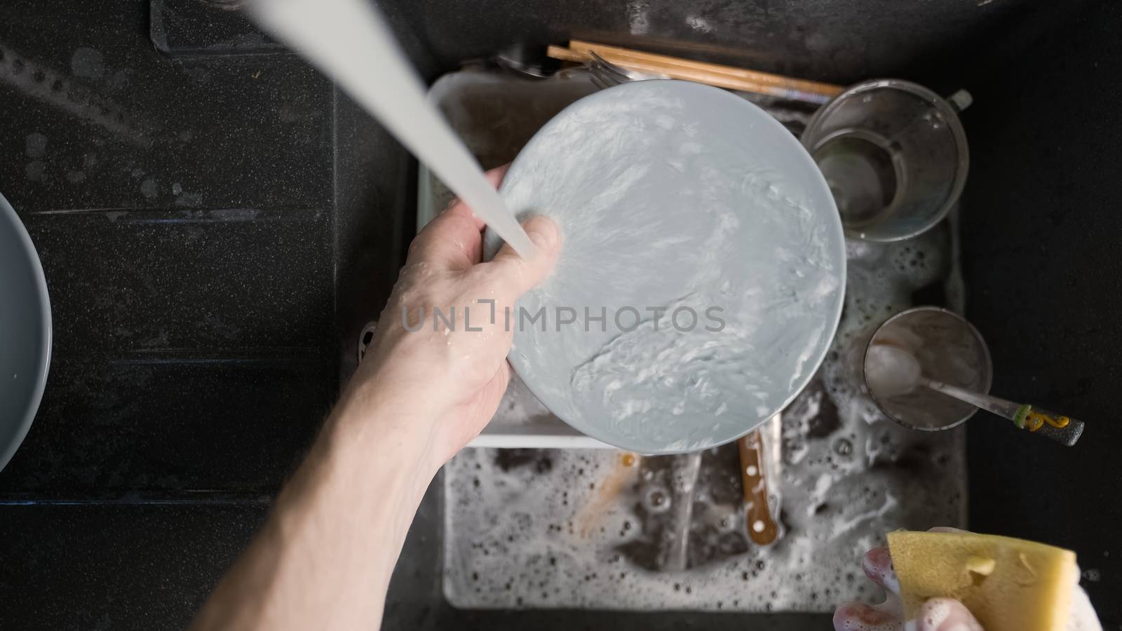 Washing dirty dishware in black sink closeup photo