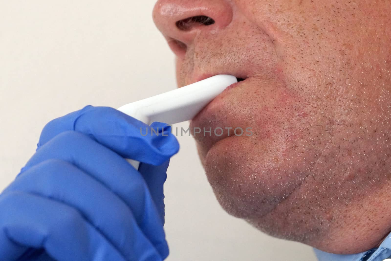 old man breathing through an inhaler, portrait close up