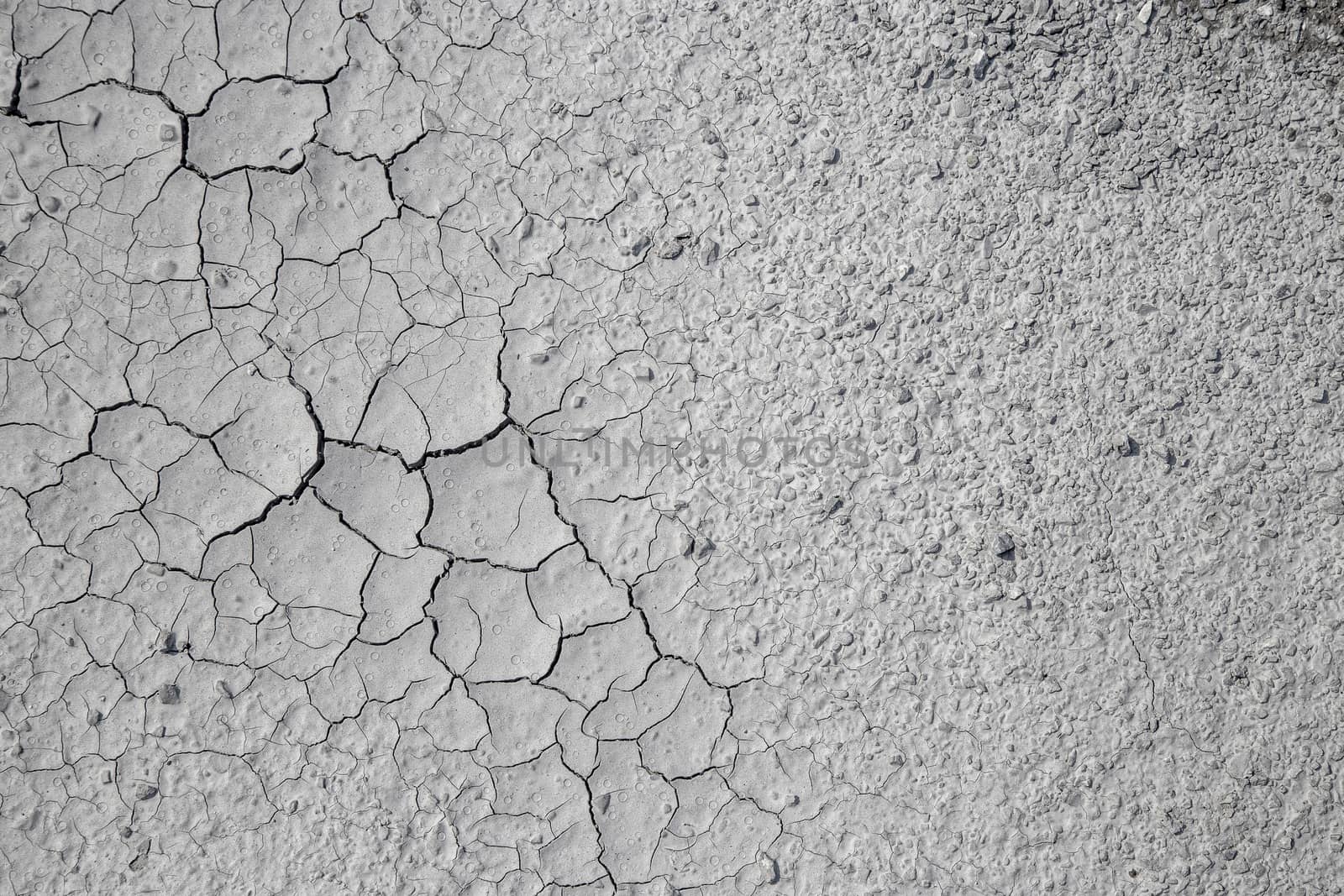 Dried cracked clay texture and gravel stones