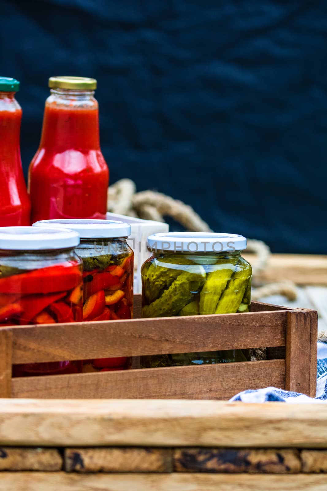 Bottles of tomato sauce, preserved canned pickled food concept isolated in a rustic composition.