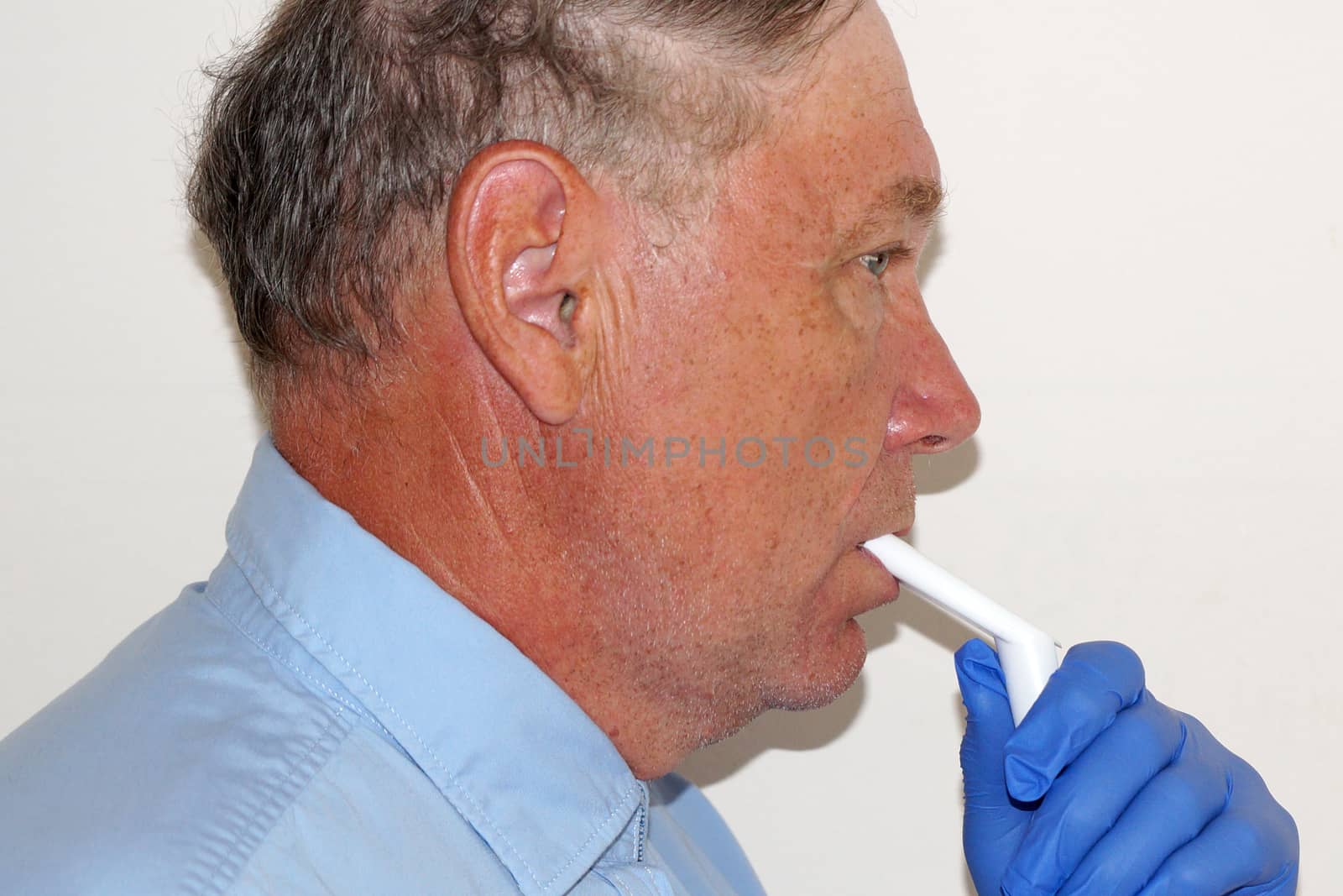 old man breathing through an inhaler, portrait close up