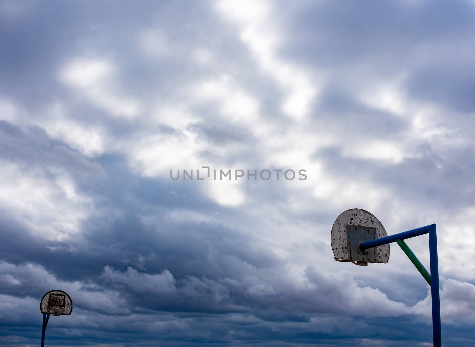 Dramatic skyling with basketball hoops in foreground by rushay