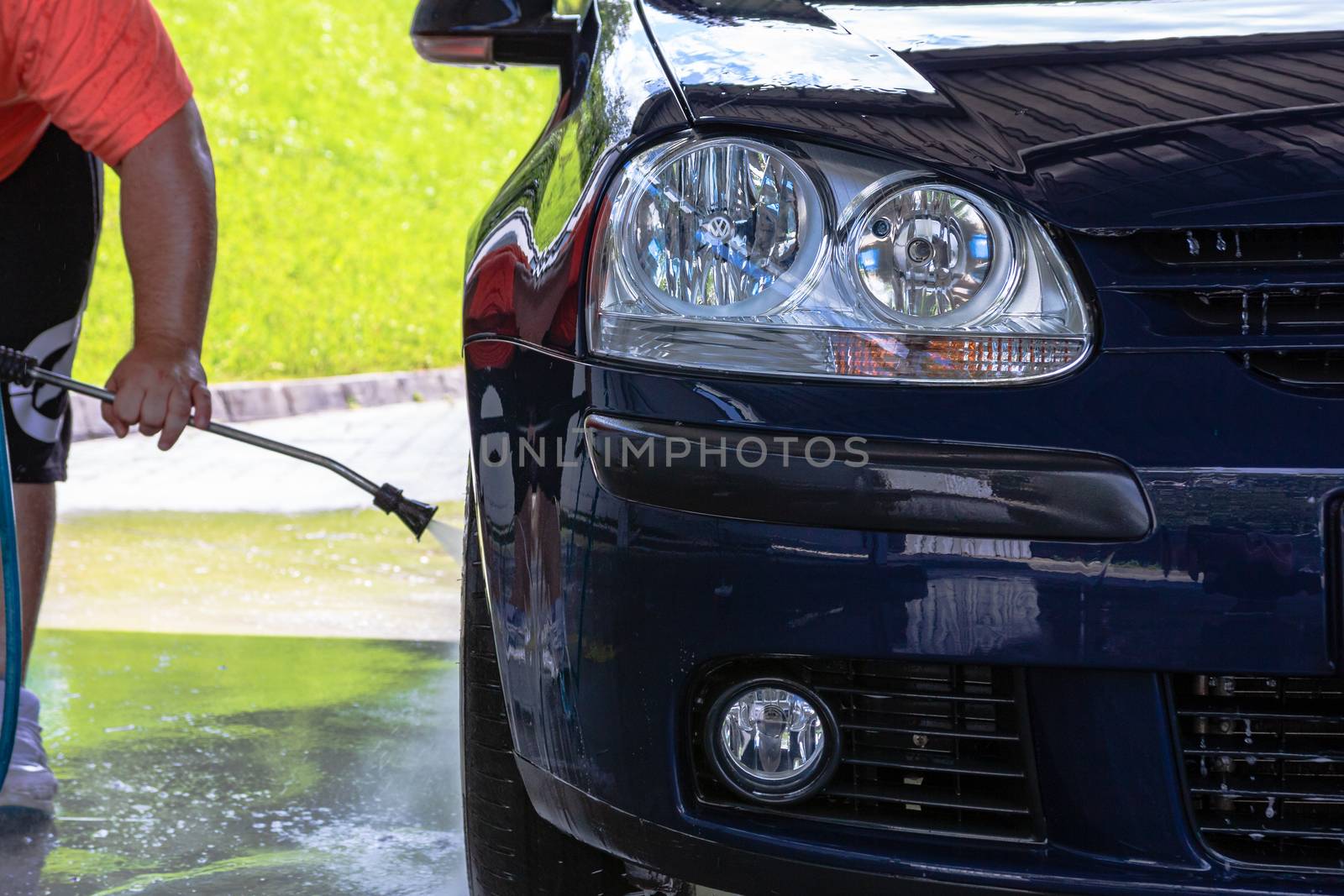 Washing and cleaning car in self service car wash station. Car washing using high pressure water in Bucharest, Romania, 2020