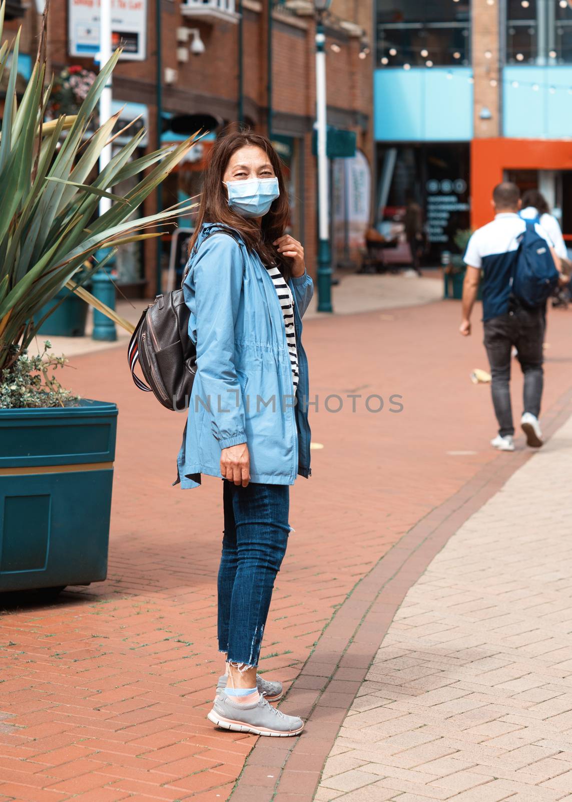Asian woman wearing a face mask walking around city and shopping