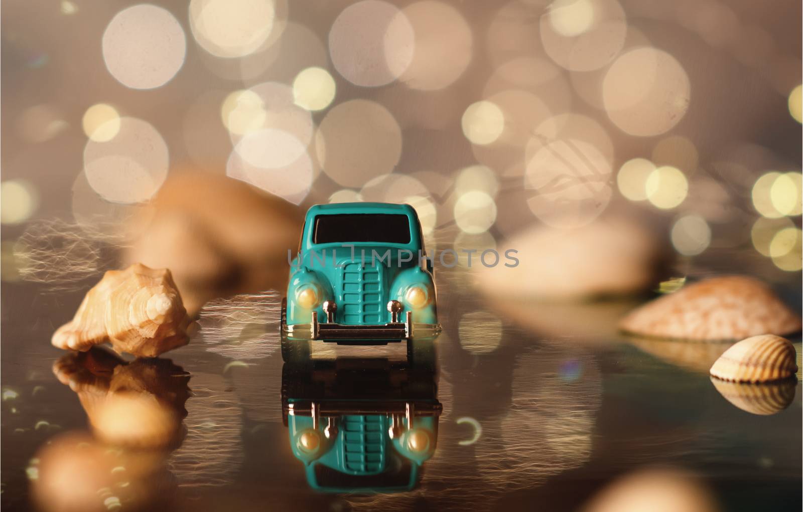 Toy car on the seaside between seashells on the background of bokeh