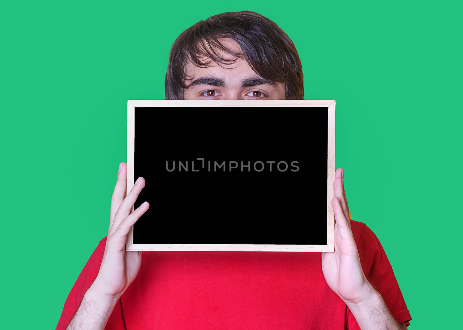 A young man holding Mockup of chalkboard on green background