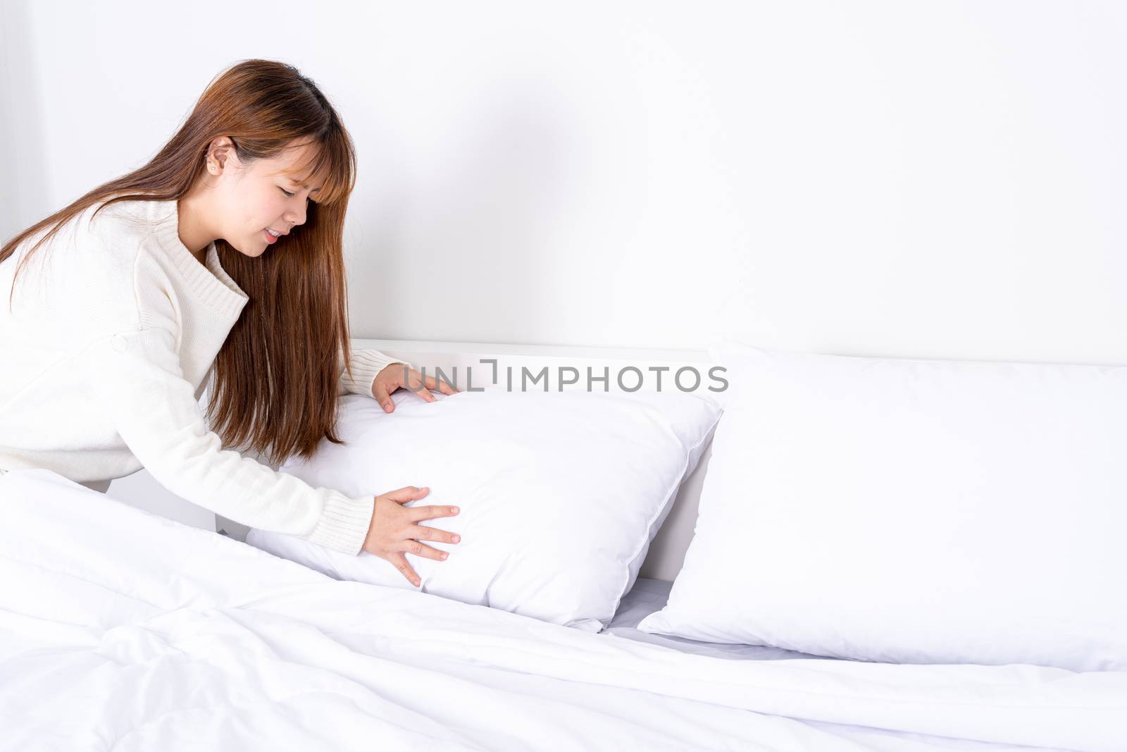 Beautiful Asian women making bed in room early in the morning. daily life concept.