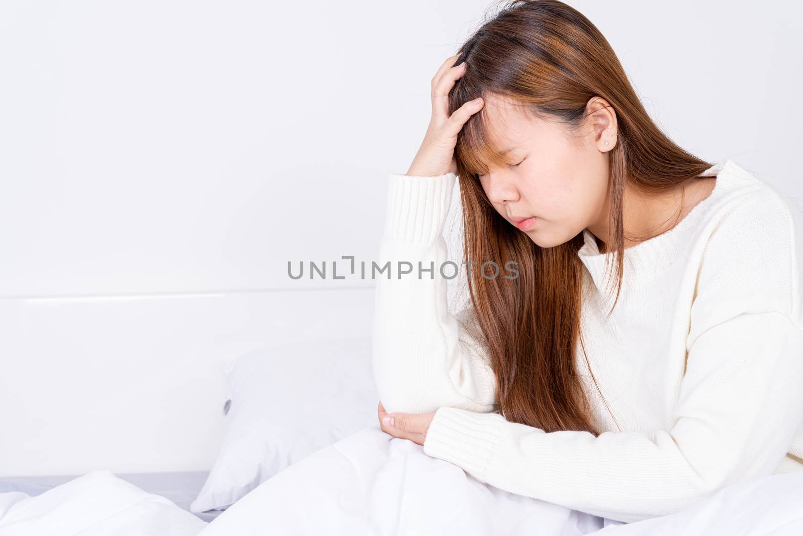 Young woman suffering from headaches after wake up on the bed. Healthcare medical or daily life concept. by mikesaran