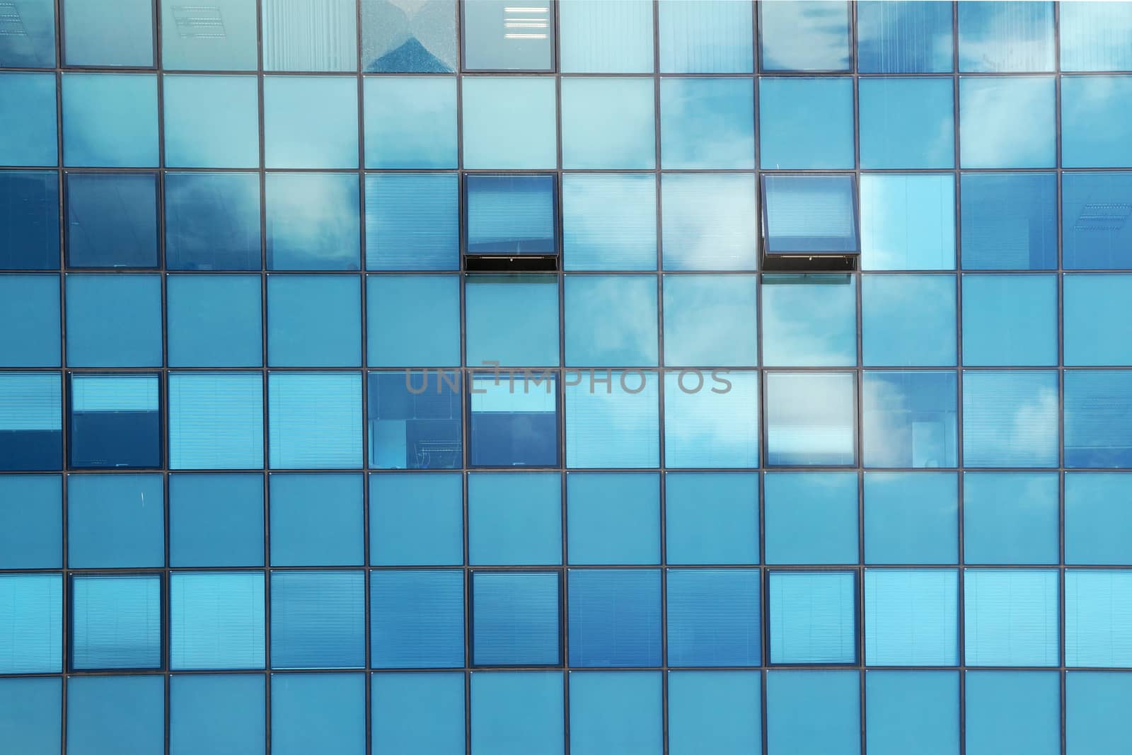 Clouds reflected in the glass facade of a skyscraper by Annado