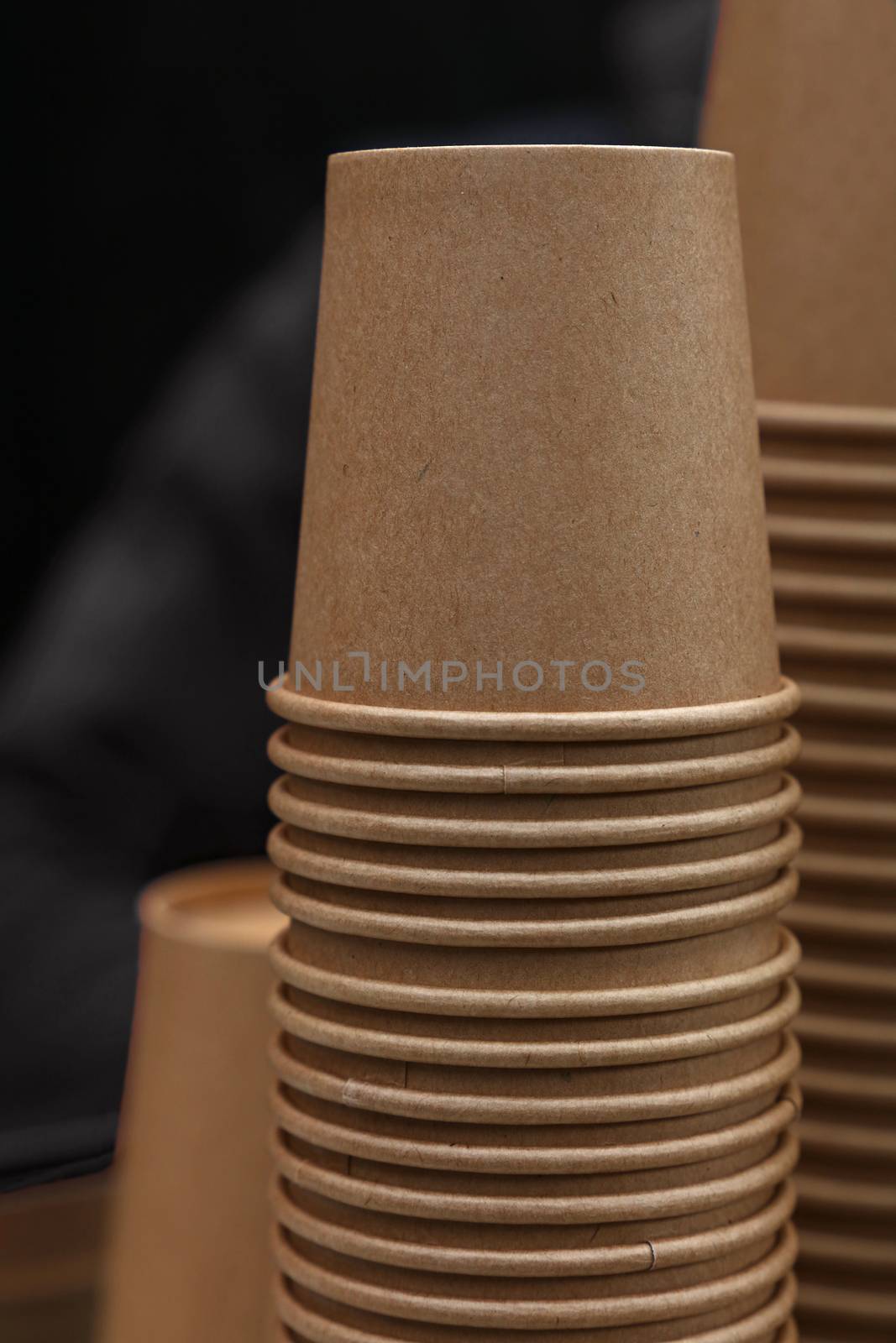 Stack of brown coffee paper cups close up by BreakingTheWalls