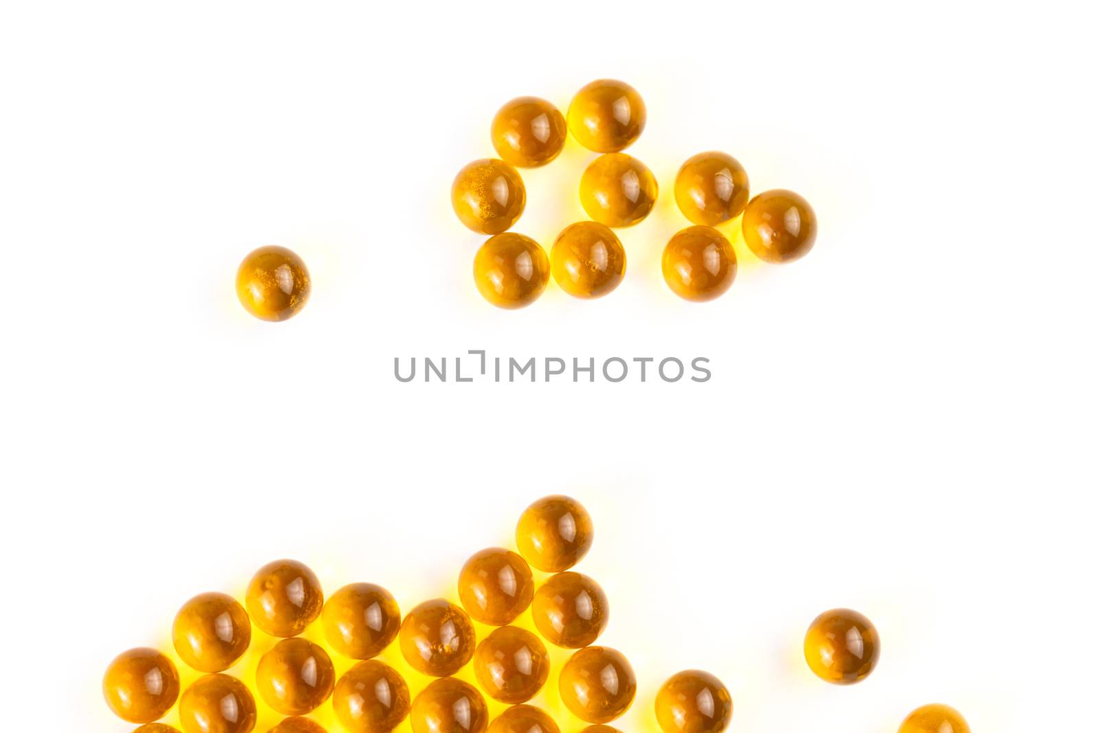 orange spherical ball capsules of fish oil selective focus isolated on white background.