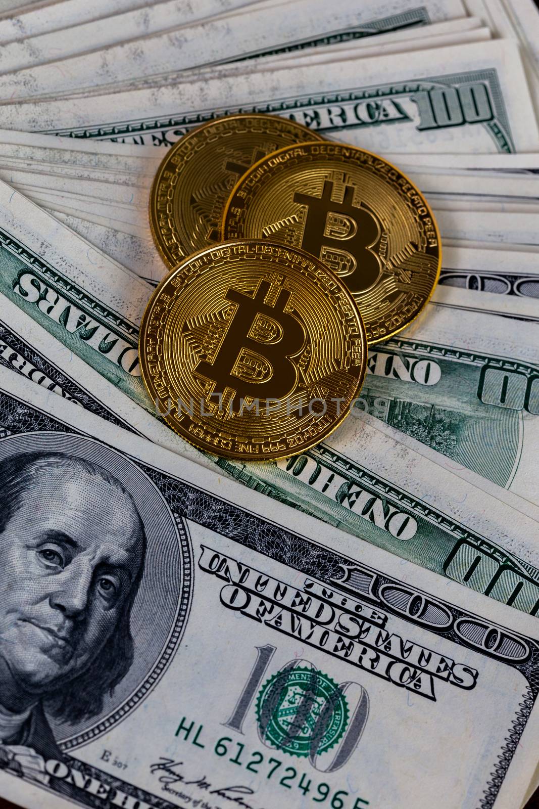 three bitcoin shiners on paper us dollar banknotes background.