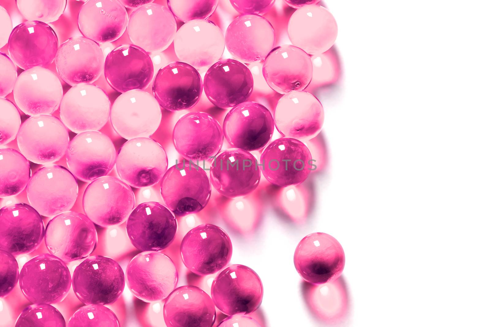 plastic pink spherical ball capsules with selective focus isolated on white background.