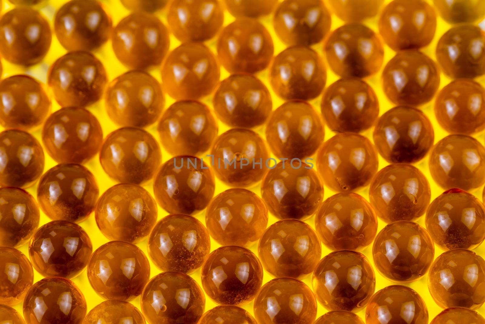 orange spherical ball capsules of fish oil selective focus background.
