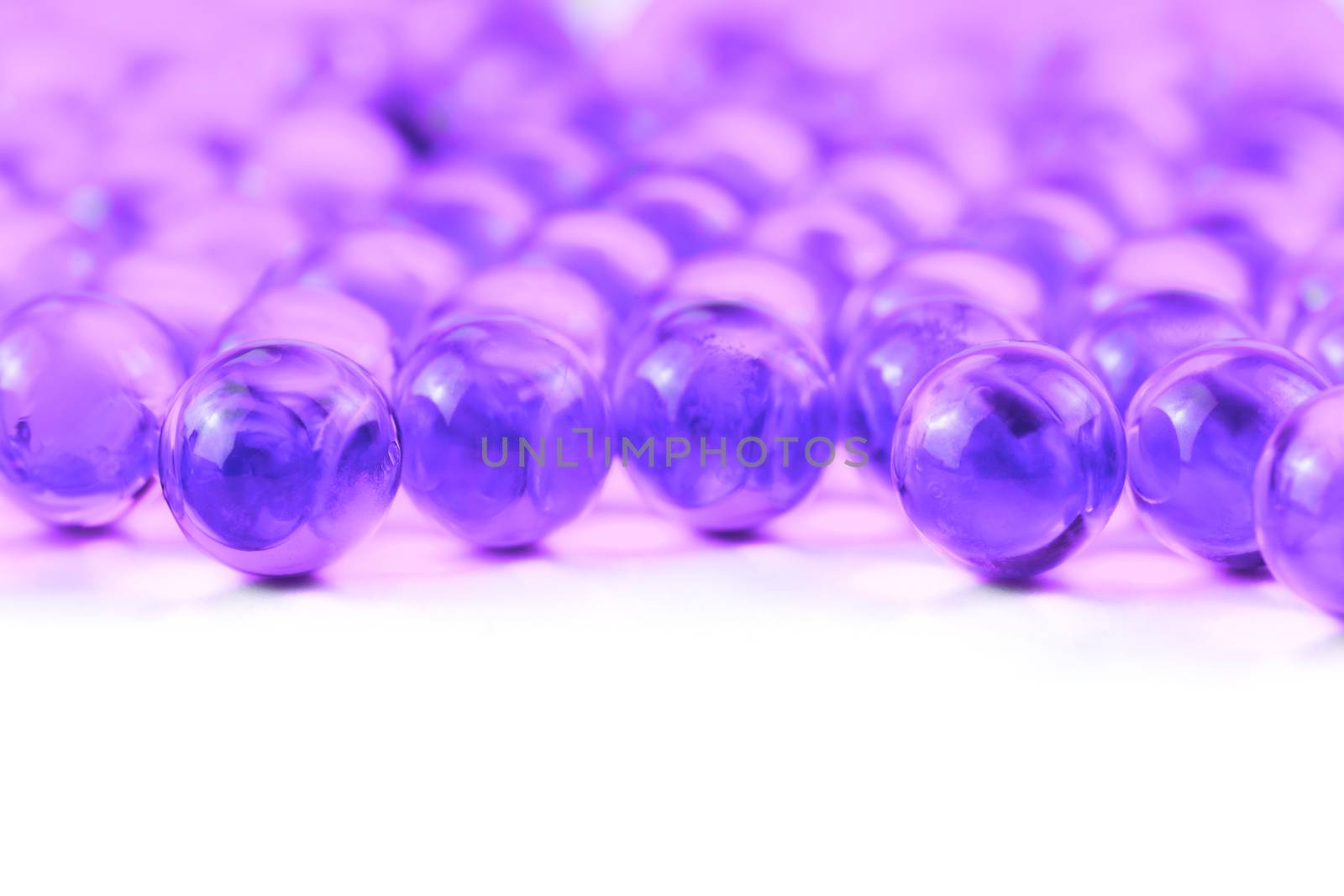 proton purple spherical ball capsules with selective focus isolated on white background.