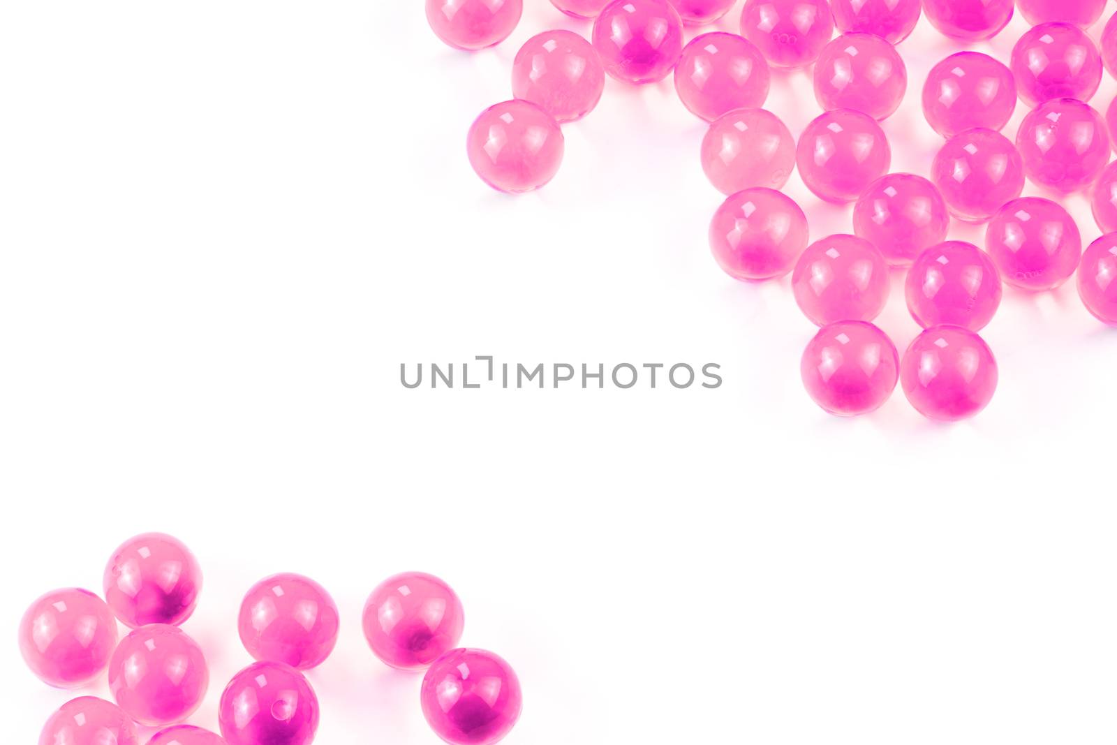 plastic pink spherical ball capsules with selective focus isolated on white background.