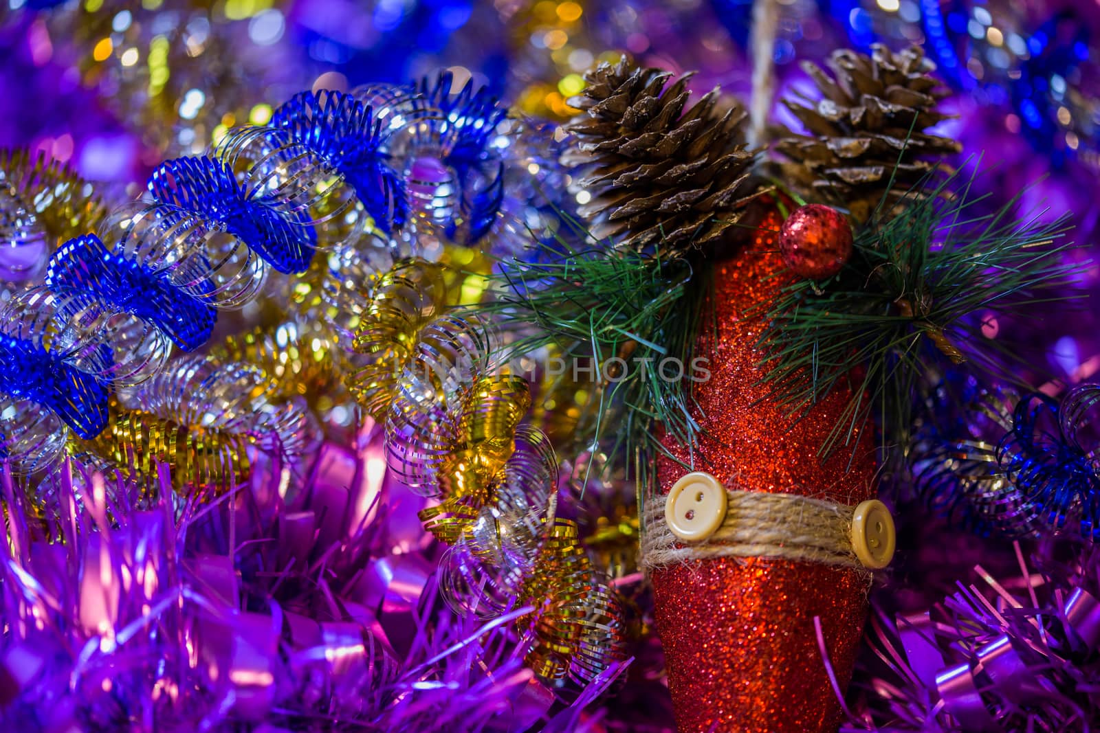 Christmas holidays composition with red gliter cone in colored tinsel - close-up with selective focus an bokeh