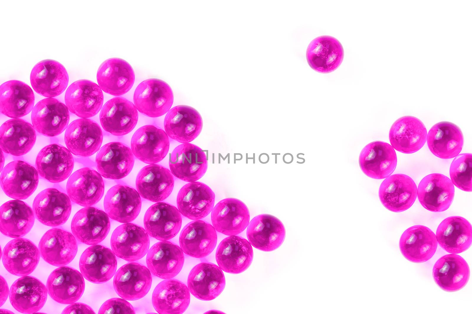 plastic pink spherical ball capsules with selective focus isolated on white background.