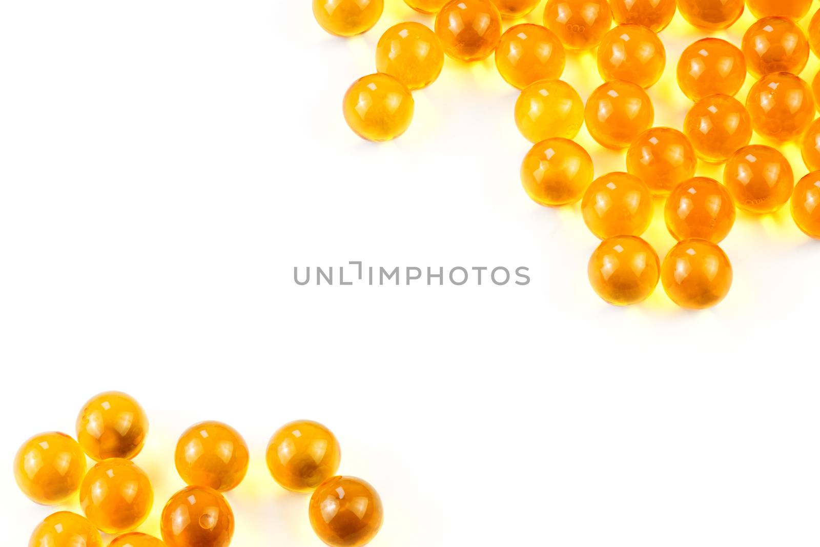orange spherical ball capsules of fish oil selective focus isolated on white background.