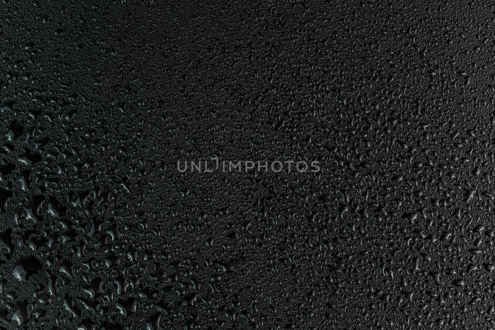 water drops on flat black rubber surface dark macro background